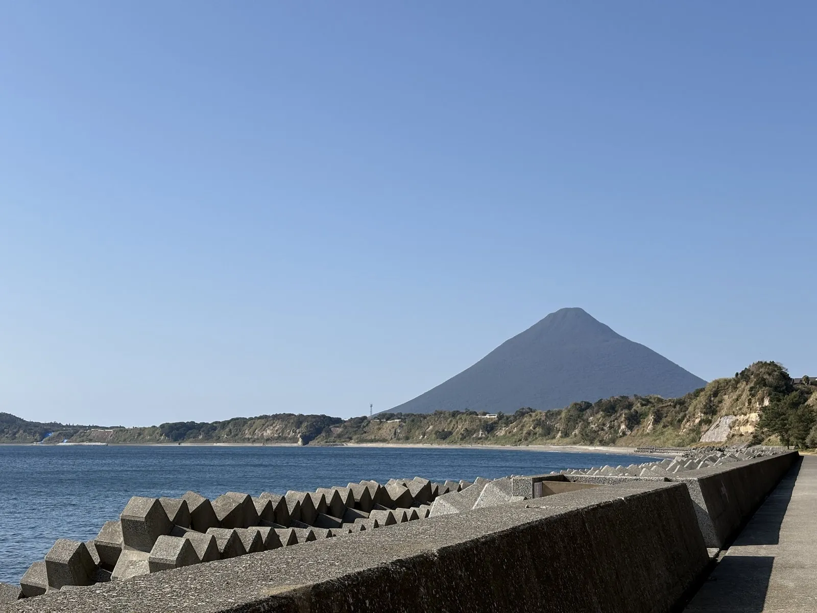 砂むし温泉へ向かう海沿いの道から初めて見えた開聞岳。手前に防波堤とテトラポッド