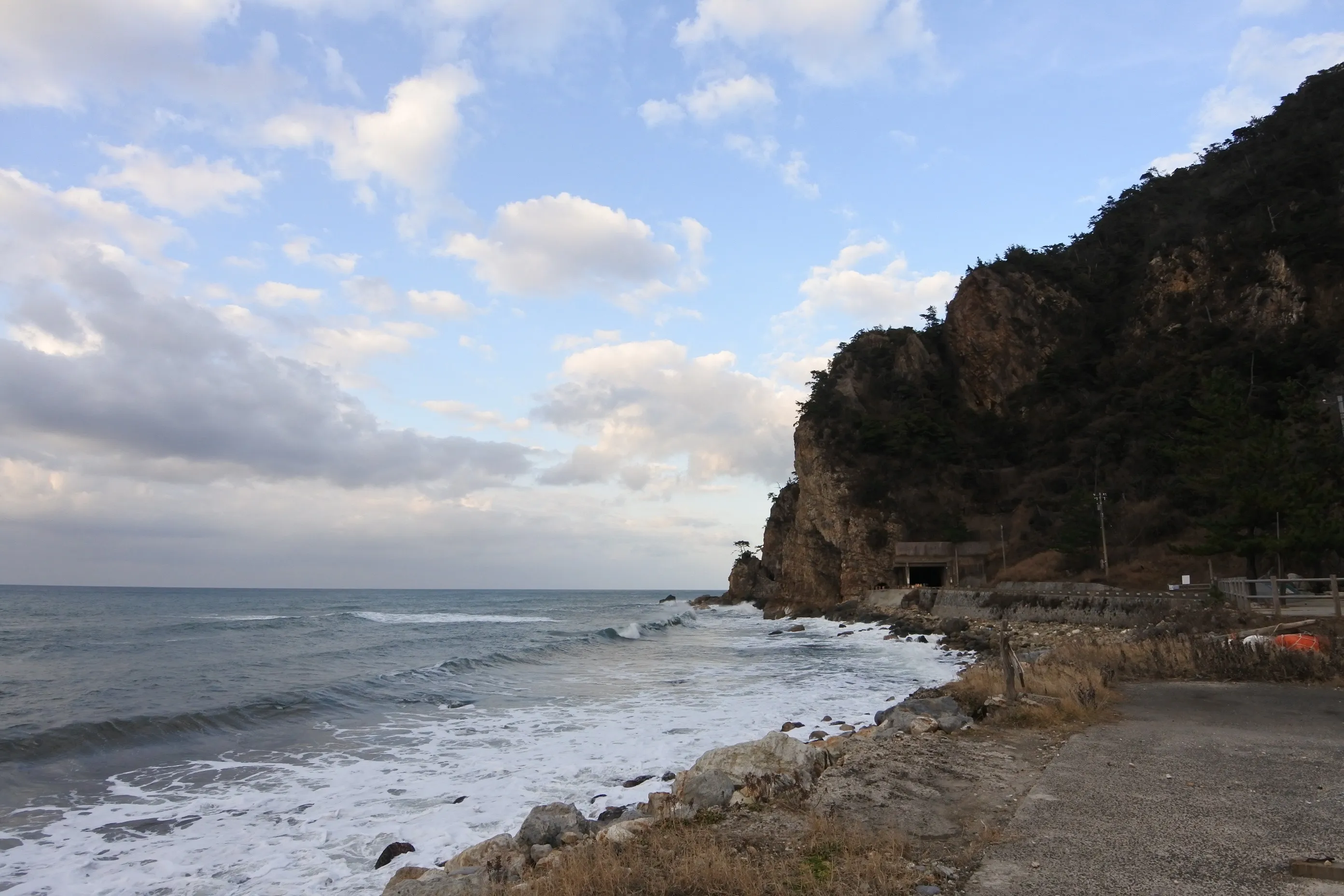 A winter cove on Noto, with cliffs and a wide cloudy sky — the rugged face of the outer coast