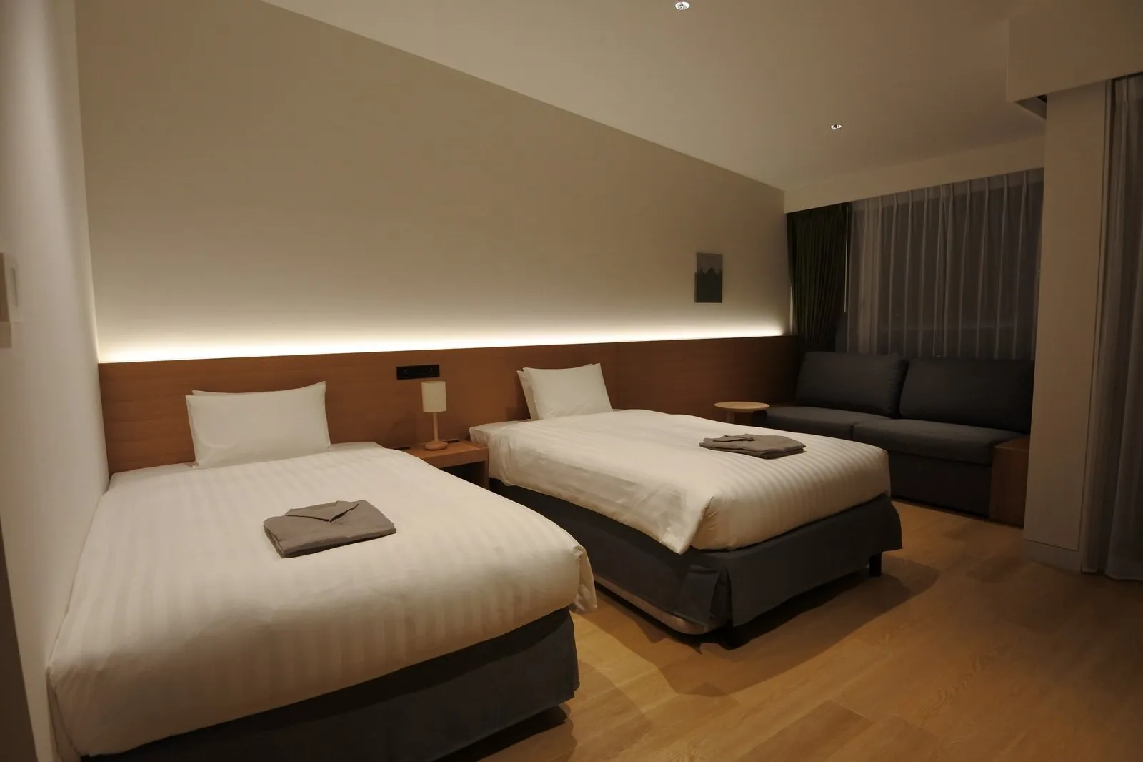samana hotel Yakushima の客室。広く新しい室内に大きなソファが置かれている